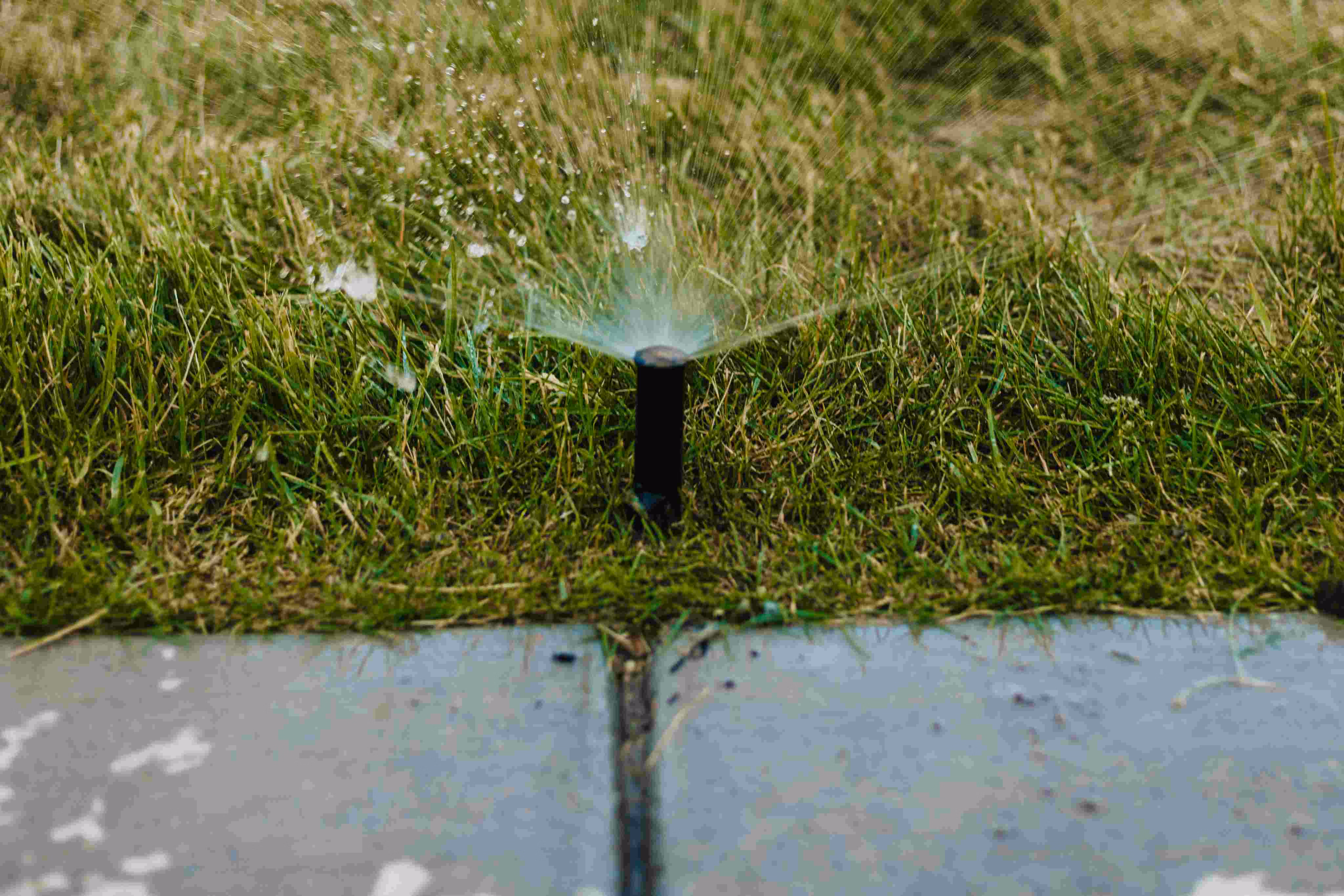 Sprinkler heads spraying water on a Utah lawn - pressurized irrigation secondary water