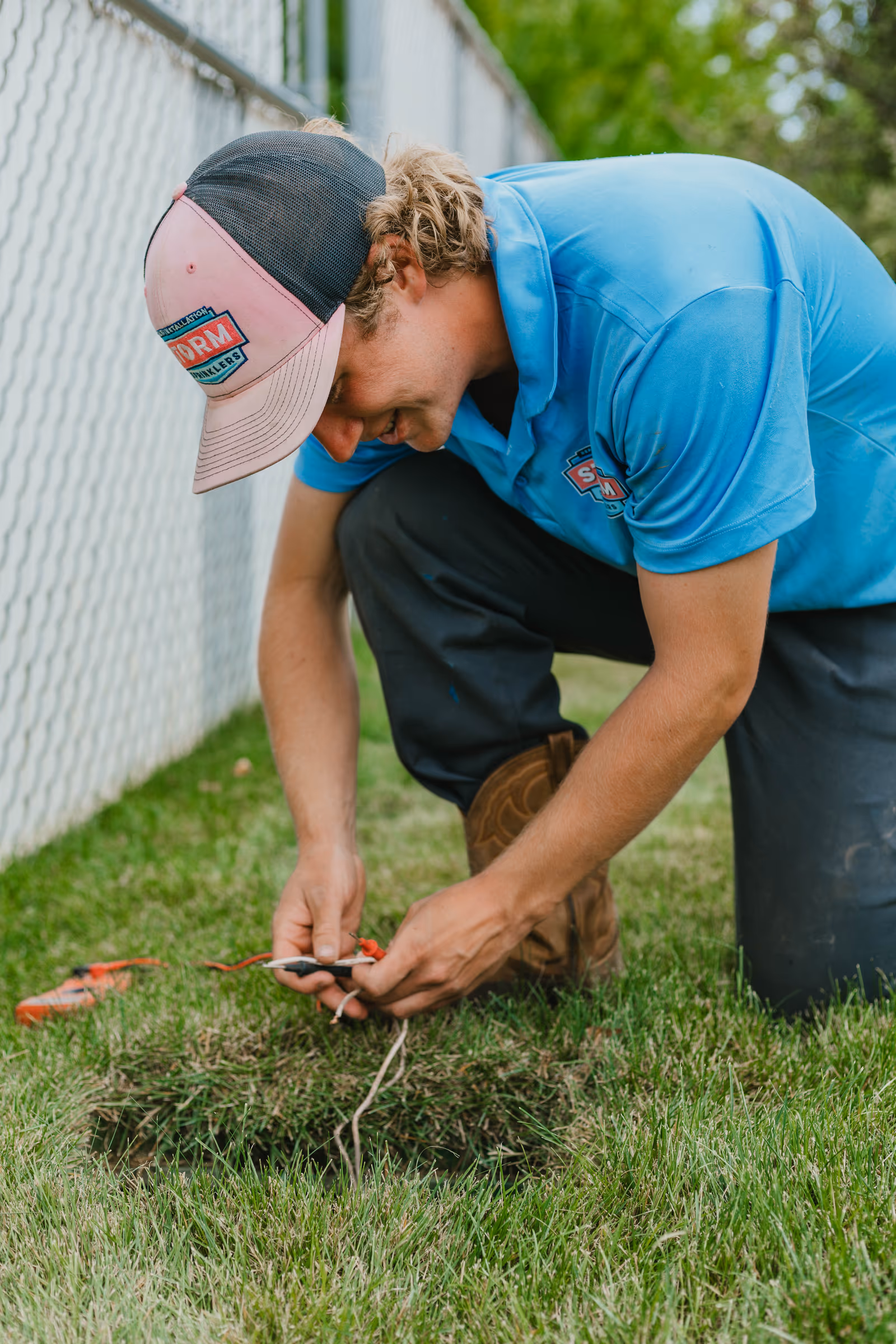 Storm Sprinklers technician troubleshooting irrigation wiring with a multimeter
