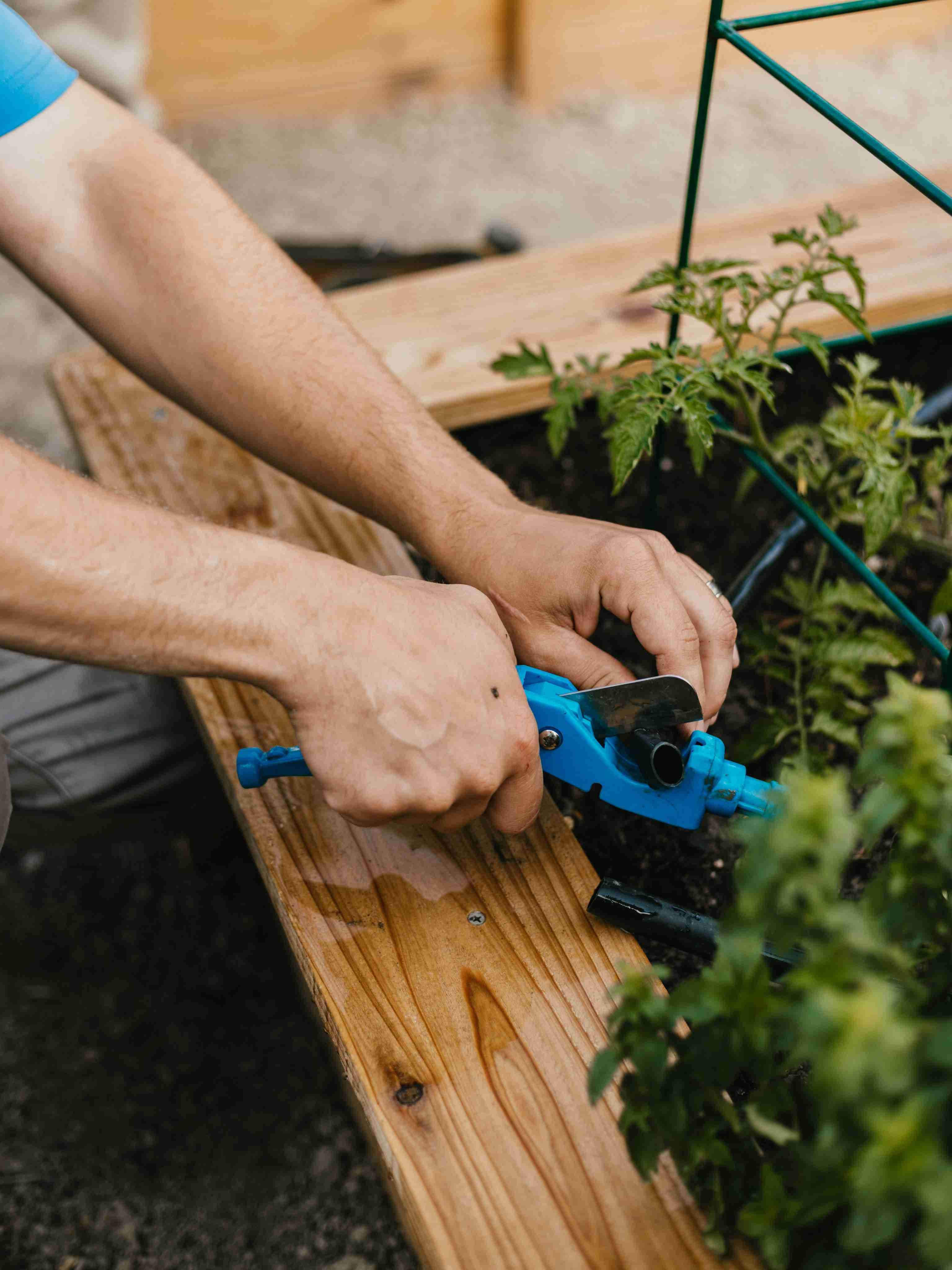 Storm Sprinklers technician repairing drip irrigation line in Utah garden bed